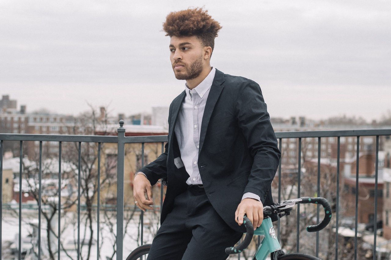 The Velo Barber bikes around in the O.N.S clothing Conduit Packable Blazer and Conduit Packable Pants